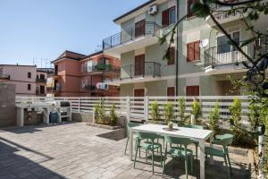 a patio with tables and chairs in front of a building at Ambrosia Room & Apartment in Rossano