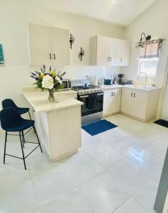 a kitchen with a vase of flowers on a counter at Jamaica Coastal Getaway in Discovery Bay