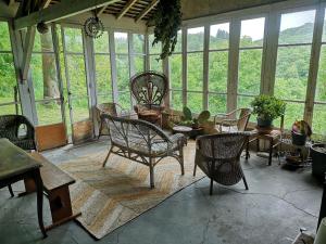 a room with chairs and tables and windows at Cottage LAISSER VERDURE in Gargilesse-Dampierre