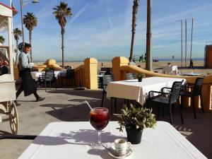 a man walking past a table with a glass of wine at Dorado Cabanyal - Luxury Beachside Charm in Valencia