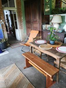 a patio with a wooden table and a bench at Cottage LAISSER VERDURE in Gargilesse-Dampierre +14 photos