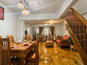 a dining room and living room with a wooden table at Aphilapa House in Chiang Mai
