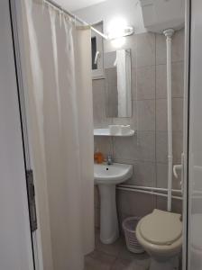 a white bathroom with a toilet and a sink at casa Olga 2 Mai in 2 Mai +57 photos