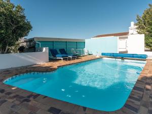 a swimming pool with blue water in a backyard at Bonne Esperance, Simon's Town in Simonʼs Town