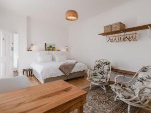 a bedroom with a bed and a table and chairs at Bonne Esperance, Simon's Town in Simonʼs Town +117 photos