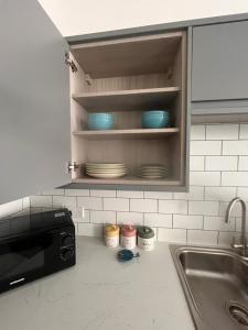 a kitchen counter with a sink and plates in a cabinet at Stunning 2 bed apartment - central Norwich in Norwich +53 photos