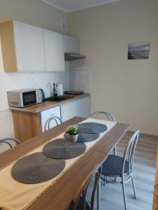 a kitchen with a wooden table with chairs and a tableasteryasteryasteryasteryastery at Villa Rowena in Rowy
