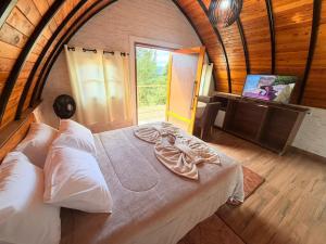 a large bed in a room with a window at Recanto sol nascentre cabanas in Monte Verde