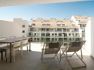a balcony with a table and chairs and a building at Meral Units in Fuengirola