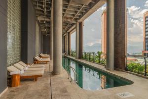 an indoor pool with chaise lounges and chairs on a building at Wake BioHotel, a Member of Design Hotels in Medellín