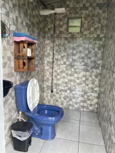a bathroom with a blue toilet in a room at Kombi Home in Piedade