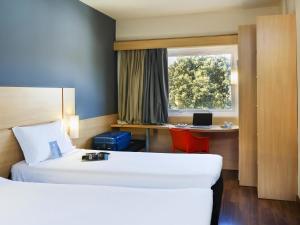 a hotel room with a bed and a desk at ibis Paulinia in Paulínia