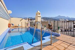 a swimming pool on top of a building at Apartamentos Nerjaluna in Nerja