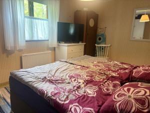 a bedroom with a bed with a purple blanket at Hus Rusken in Stockaryd