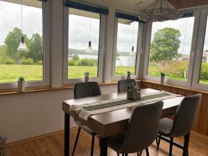 a dining room with a table and chairs and windows at Hus Kalvsjö in Kalv