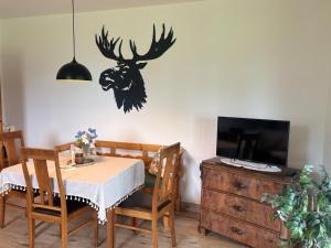 a dining room with a table and a deer head on the wall at Hus Kalvsjö in Kalv