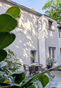 a white building with chairs and a table in front of it at Apartament Retro in Paczków