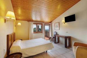 a bedroom with a bed and a desk and a television at Ball de Diables in Sant Pau dʼOrdal +17 photos