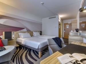 a hotel room with a bed and a couch at Novotel Köln City in Cologne +119 photos
