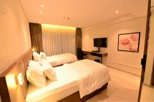 a hotel room with two beds and a television at HOTEL ANUPAM RESIDENCY in Mumbai