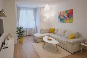 a living room with a couch and a table at MM Central Apartment with Parking in Skopje