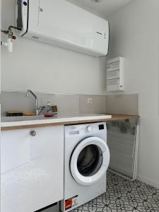a washing machine in a kitchen with a sink at Maison Fontanille in Le Puy-en-Velay