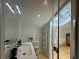 a white bathroom with a sink and a mirror at Maison Fontanille in Le Puy-en-Velay