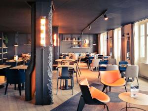 a dining room with tables and chairs and tablesktop at Mercure St Malo Front de Mer in Saint Malo
