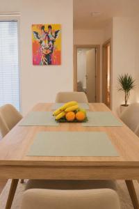 a wooden table with bananas and oranges on it at MM Central Apartment with Parking in Skopje