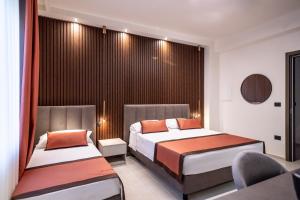 a hotel room with two beds and a chair at Ambrosia Room & Apartment in Rossano