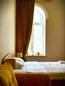 a bedroom with a large bed with a window at Gallery inn in Kutaisi