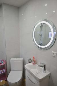 a bathroom with a white toilet and a mirror at MM Central Apartment with Parking in Skopje +8 photos