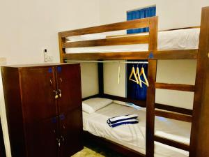 a bedroom with two bunk beds and a closet at Lagoon Hostel in Arugam Bay