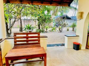 a wooden bench in a room with a view of a beach at Lagoon Hostel in Arugam Bay +41 photos