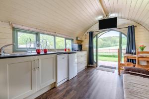a kitchen with white cabinets and a large window at 1 Bed in Hereford oc-81292 in Aconbury