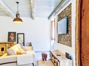 a living room with a couch and a tv on a wall at Apartment Novecento by Interhome in Monterotondo