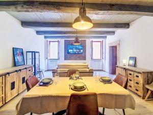 a dining room with a table and chairs and a television at Apartment Novecento by Interhome in Monterotondo