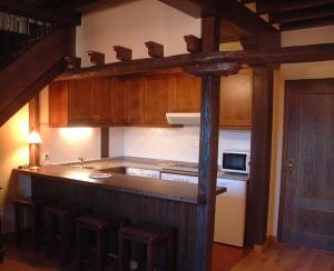 una cocina con encimera y algunos armarios de madera en Apartamentos Villa de Potes, en Potes