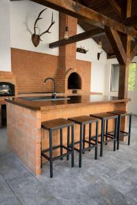 a kitchen with a counter with a sink and some stools at The Nest Apartment in Sovata