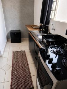 a kitchen with a stove and a sink at Cantinho Da Go in Caraguatatuba +17 photos