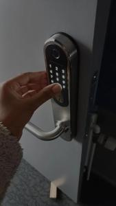 a person holding a cell phone on a door at Double Room 9 in Saeby in Sæby