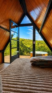 a bedroom with a large window and a bed at Chalé Suiço Diniz e Ferreira in Contagem +7 photos