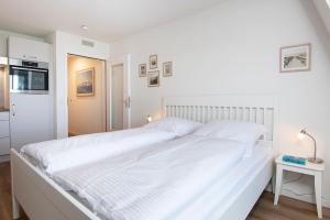a large white bed in a white bedroom at Kleine Meerzeit in Dahme
