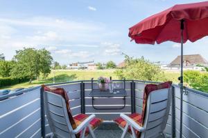 a patio with two chairs and a table with an umbrella at Kleine Meerzeit in Dahme