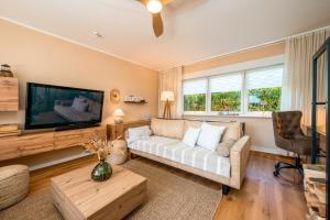 a living room with a couch and a flat screen tv at Ferienhaus Sonneneck in Kluis