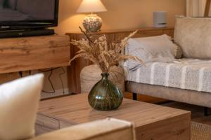 a living room with a vase with flowers on a coffee table at Ferienhaus Sonneneck in Kluis
