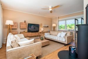a living room with two couches and a flat screen tv at Ferienhaus Sonneneck in Kluis