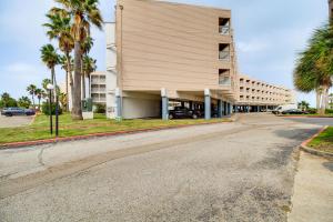 an empty street in front of a building with palm trees at Unwind by the Beach | Pool and Oceanfront View in Corpus Christi