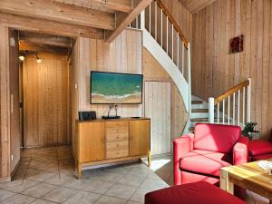 a living room with a staircase and a red chair at Seebrise Baabe in Baabe
