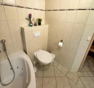 a bathroom with a toilet and a bath tub at Seebrise Baabe in Baabe